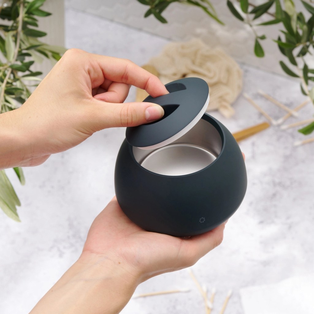 A hand lifting the lid off, tank visible