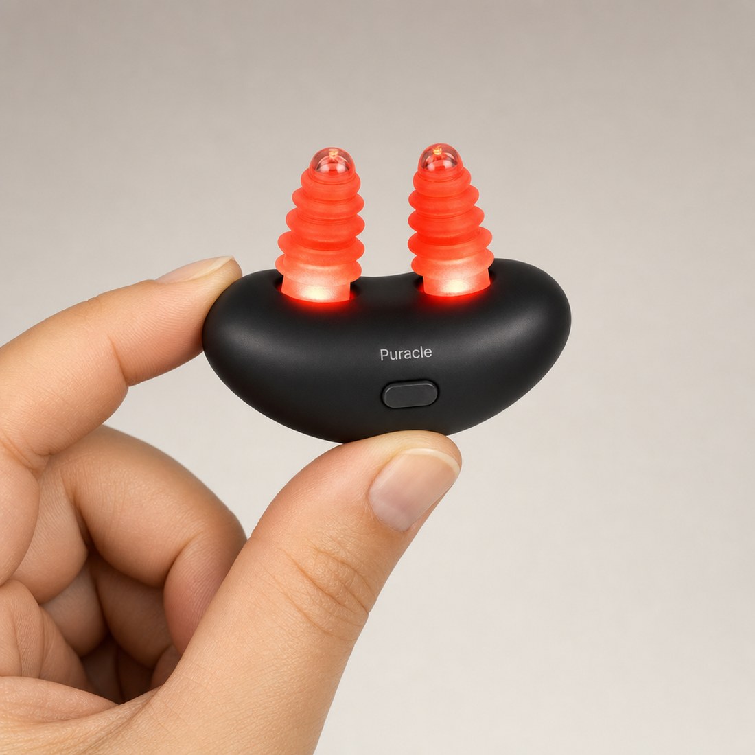 The device held between finger and thumb, lit, at actual size